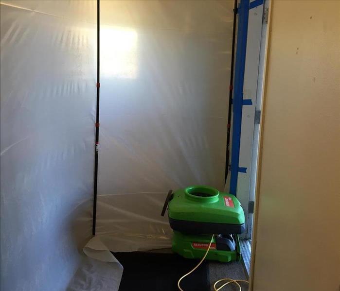 Plastic sheeting containment in a home with black mold.